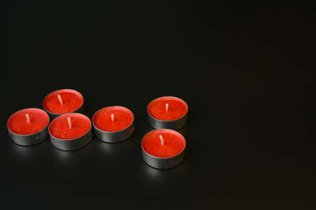 A lot of red small holiday candles on a black background.の写真素材