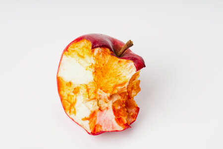 A gnawed apple on a white background closeup.の写真素材