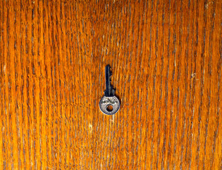 A small key on a wooden surface. Top viewの写真素材