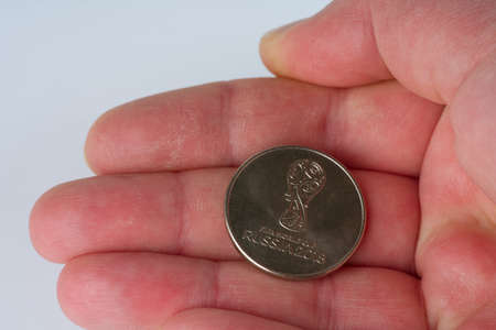 MOSCOW, RUSSIA-November 17, 2021: In his hand is a coin issued for the 2018 Football World Cupのeditorial素材