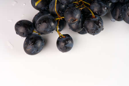 Black juicy grapes on a white background closeupの写真素材