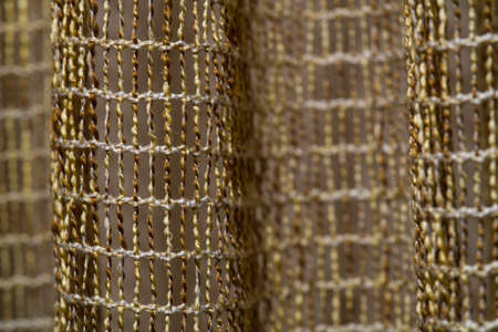 The texture of the curtains in the form of a brown mesh closeupの写真素材