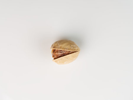 One pistachio on a white background closeup. Top view.