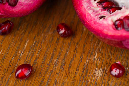 Bright red pomegranate seeds and the fruit itself in the backgroundの写真素材
