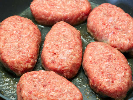 Raw cutlets are fried in a frying pan closeの写真素材
