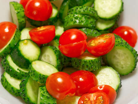 Green vegetarian salad of red cherry tomatoes and cucumber. Closeupの写真素材