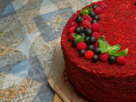 Half of a red birthday cake with berries and mint leavesの写真素材