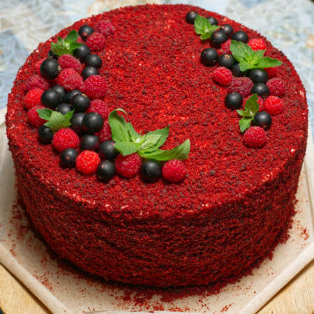 A whole red birthday cake decorated with currant and raspberry berriesの写真素材