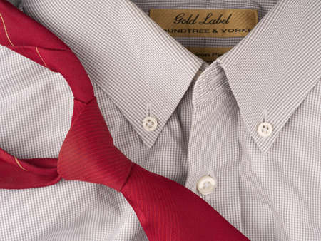 MOSCOW, RUSSIA-February 23, 2022: A light checkered office shirt with buttons on the collar and a red tie lying next to it. Closeupのeditorial素材