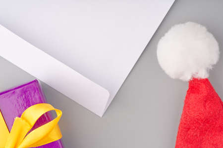 A New Years gift and a Santa Claus hat. There is a white envelope with a letter next to it. Top viewの写真素材
