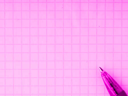 A pen on the background of a notebook sheet in pink tones. Closeup. Place for textの写真素材