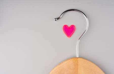 Concept I love shopping. A clothes hanger and a heart on a gray background. Space for textの写真素材