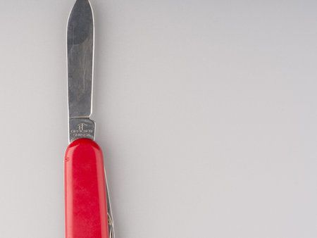 MOSCOW, RUSSIA-February 23, 2022: Swiss knife with the blade pulled out on a gray background closeup. Space for textのeditorial素材