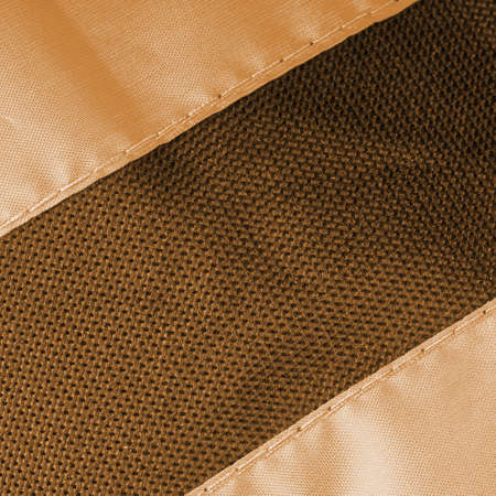 A piece of fabric with a black stripe sewn into it. Everything is in gray and gold tones. Closeupの写真素材