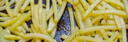 Golden colored French fries fried in a frying pan at home. Closeupの写真素材