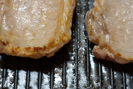 Two pork steaks in a frying pan. Closeup. Supperの写真素材