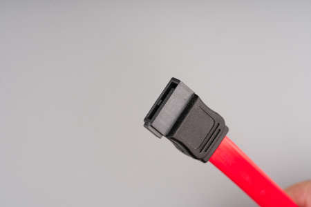 Red and black computer wire on a gray background. Closeupの写真素材