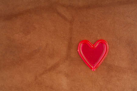 Red heart on the background of natural light skin. Closeup. Space for textの写真素材