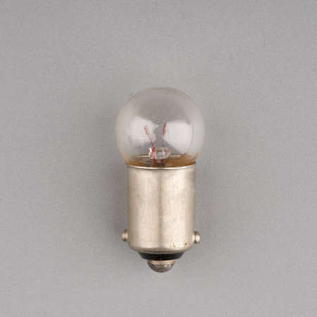 A small old light bulb on a gray background. Closeupの写真素材