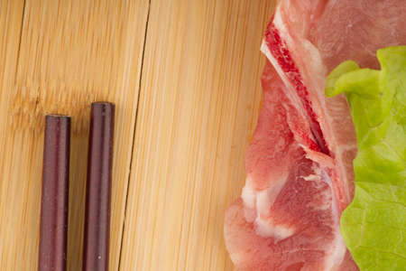 Meat with lettuce leaf and Chinese chopsticks. Closeupの写真素材