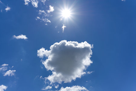 There are a few clouds and a shining sun in the blue sky. Bottom viewの写真素材