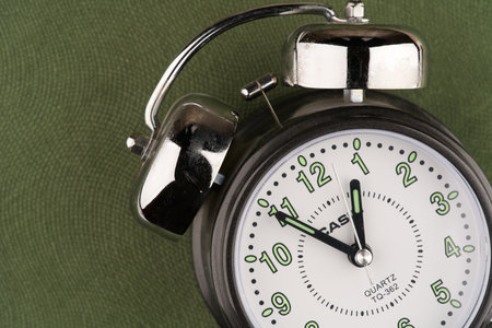 Moscow, Russia-September 16, 2022: Alarm clock on a green background. Closeup. Space for textのeditorial素材