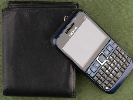 Moscow, Russia-September 16, 2022: An old Nokia E63 push-button phone with a qwerty keyboard and a wallet closeupのeditorial素材