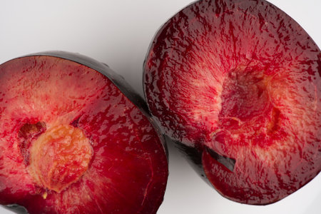 Juicy plum cut in half on a white background. Closeup. Top viewの写真素材