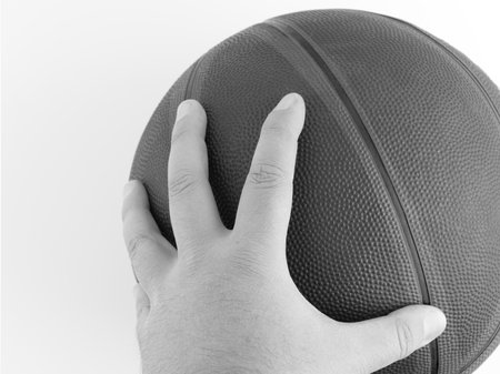 A basketball with a hand in black and white. Space for textの写真素材