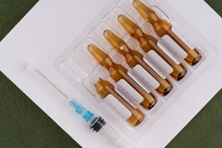 Ampoules with medication for injections and a syringe nearby. top view.の写真素材