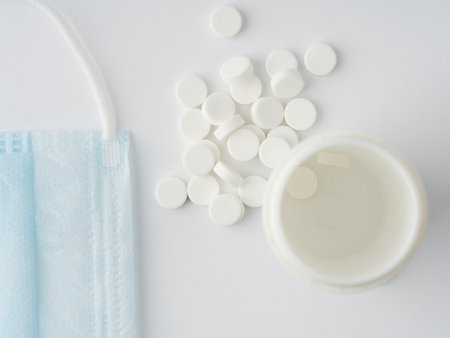 Tablets with a tube and a medical mask on a white background. closeup.の写真素材