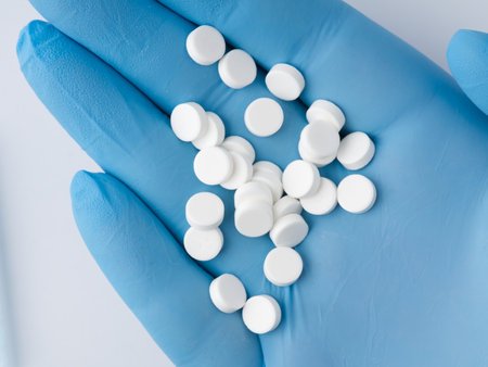 There are a lot of pills in the hand. Which is in a blue medical glove.の写真素材