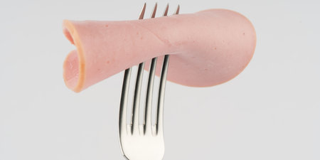 Sausage on a fork. closeup. On a white background.の写真素材
