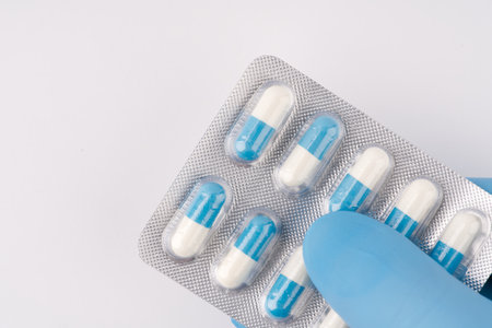 In his hand in a blue medical glove pills. closeup.の写真素材