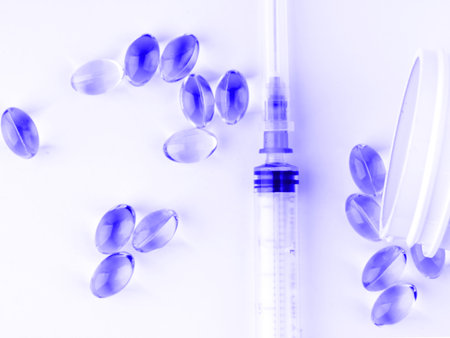 Tablets and syringe in blue colors. closeup.の写真素材