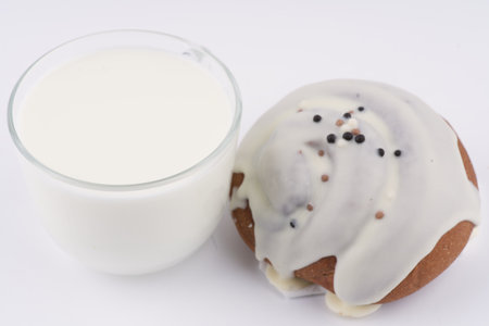 A glass of milk and a delicious bun on a white background. closeup.の写真素材