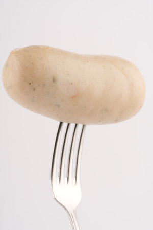 Sausage on a fork on a white background. Closeup.の写真素材