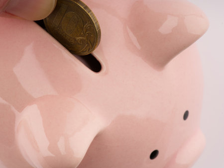 They put a coin in the piggy bank. Closeupの写真素材