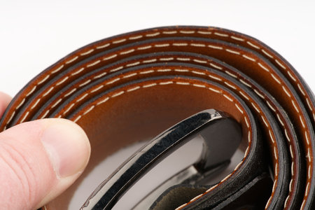Leather black belt on a white background closeupの写真素材