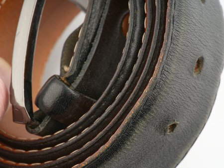 Leather black belt on a white background closeupの写真素材