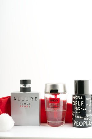 Moscow, Russia-October 16, 2022: A lot of mens branded perfumes and a Santa Claus hat on a white background. Vertical shotのeditorial素材