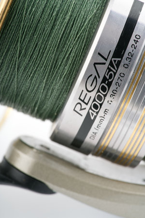 Moscow, Russia-October 16, 2022: Moscow, Russia-October 16, 2022: Branded fishing reel on a white background. The spool is visible. Closeup. Vertical shotのeditorial素材