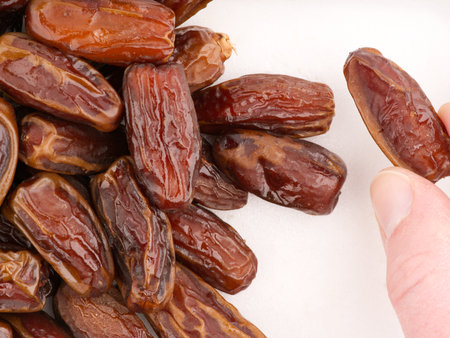 One date in the hand against the background of others. Top viewの写真素材