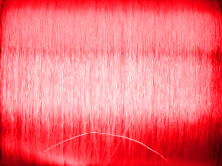 Abstract texture of straight lines from top to bottom in red. And a white spot in the middleの写真素材