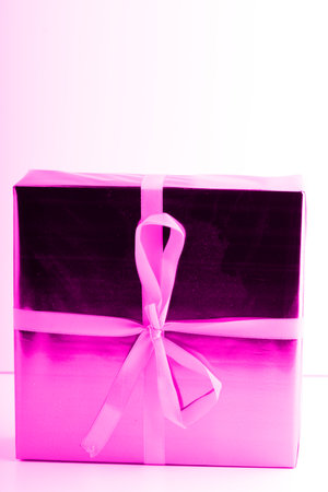 A square box with a pink New Year gift. Vertical shotの写真素材