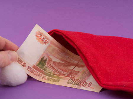 The concept of money for gifts in the New Year holiday. Money and a Santa Claus hatの写真素材