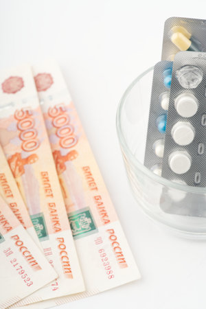Money and pills. There is not enough money for treatment. Vertical shotの写真素材