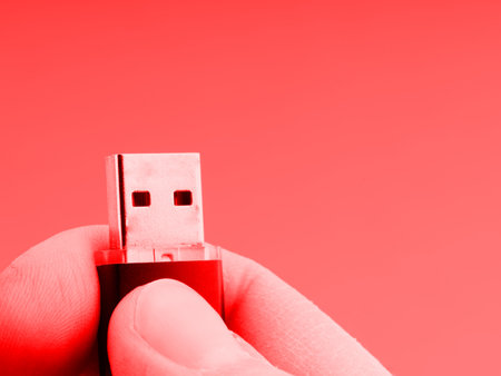 The concept of a computer virus. Flash drive in hand in red colors. Space for textの写真素材