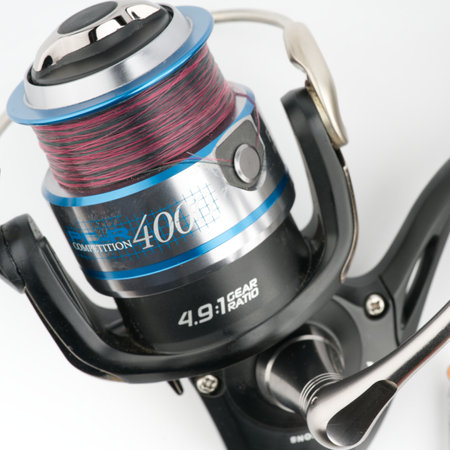 Moscow, Russia-October 16, 2022: Branded fishing reel on a white background. Closeup. View from aboveのeditorial素材