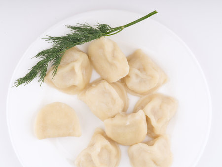 Cooked dumplings on a white plate with dill. Flatlayの写真素材